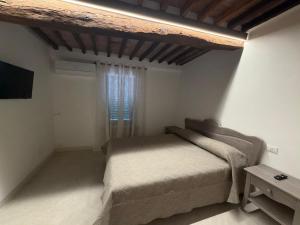 a small bedroom with a bed and a window at b&b K2R in Chiusdino