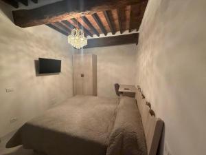 a bedroom with a bed and a desk and a chandelier at b&b K2R in Chiusdino