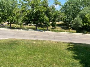 an empty street with trees on the side of the road at Del Boca Vista in Owatonna