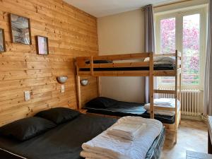 two bunk beds in a room with wooden walls at Résidence Les Dômes in Murol