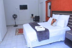 a bedroom with a large white bed with a blanket on it at Fargon Guest House in Polokwane