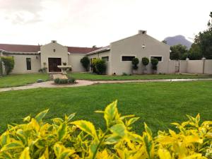 a house in a yard with a green lawn at Riverside Cottages in Graaff-Reinet