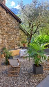 a patio with a chair and a table and a plant at BnB Casa Bellavista Sant Abbondio 6577 Ranzo in Gerra