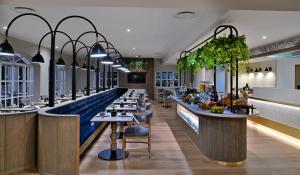 a restaurant with a long bar with tables at Courtyard Hotel Gqeberha in Port Elizabeth