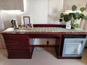 a wooden desk with a counter top with a computer monitor at Riverside Cottages in Graaff-Reinet +13 photos