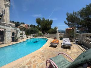 a swimming pool with two lounge chairs next to it at Chez Antoinette et Jo in Drap