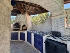 an outdoor kitchen with blue cabinets and a stove at Chez Antoinette et Jo in Drap
