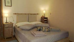 a bedroom with a bed with towels on it at Alba Andros Traditional Villa in Andros