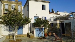 a white house with trees in front of it at Alba Andros Traditional Villa in Andros