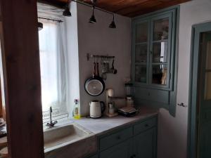 a kitchen counter with a sink and a window at Alba Andros Traditional Villa in Andros +50 photos