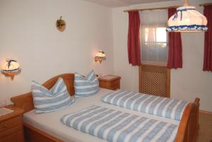 a bedroom with a bed with blue and white pillows at Vilahof in San Vigilio Di Marebbe