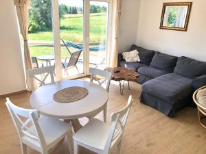 a living room with a table and chairs and a couch at Lake House Moryn in Przyjezierze