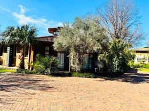 a house with a brick driveway in front of it at Kriel Windpomp Guesthouse in Aangewysd