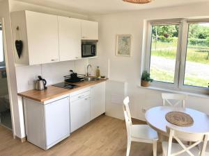 a kitchen with white cabinets and a table and a window at Lake House Moryn in Przyjezierze +17 photos