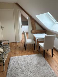 a living room with a table and chairs and a skylight at L'Atelier - Grande chambre d'hôtes in Caen