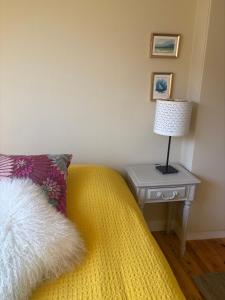 a bedroom with a bed with a table with a lamp at L'Atelier - Grande chambre d'hôtes in Caen