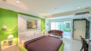 a bedroom with a bed and a chair in a room at Access Inn Pattaya in Pattaya