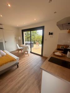 a kitchen and living room with a bed and a table at Lo Coustil in Saint-Martin-Labouval