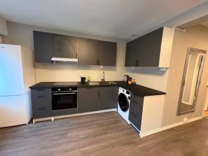 a kitchen with a refrigerator and a dishwasher at Notodden Sentrum Apartment NO 14 in Notodden +7 photos
