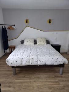 a bedroom with a bed with a white bedspread at TY Nid in Lannion
