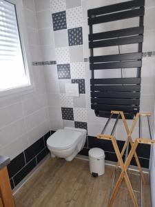 a bathroom with a toilet and black and white tiles at TY Nid in Lannion