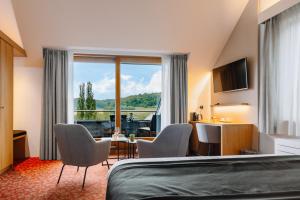 a hotel room with a bed and a table and chairs at Hotel - Appartement de Zevende Heerlijkheid in Slenaken