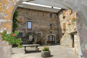 an archway in a stone building with a wooden bench at Chambres D'hôtes Le Sahut in Castelnau-Pégayrols