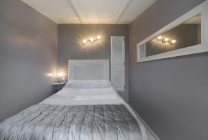 a small bedroom with a bed and lights on the wall at Le Petit Mas - Piscine Clim in Grillon