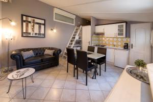 a living room with a couch and a table at Le Petit Mas - Piscine Clim in Grillon +5 photos