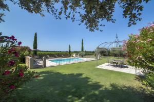 a garden with a swimming pool and a fence at Le Petit Mas - Piscine Clim in Grillon