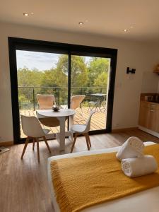 a bedroom with a bed and a table and a balcony at Lo Coustil in Saint-Martin-Labouval