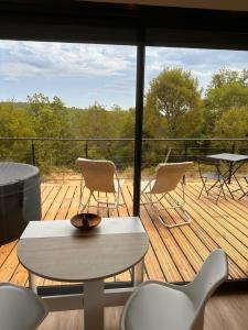 a balcony with a table and chairs on a deck at Lo Coustil in Saint-Martin-Labouval