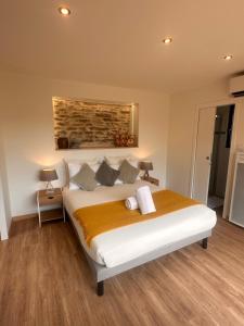 a bedroom with a large white bed with pillows at Lo Coustil in Saint-Martin-Labouval