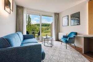 a living room with a blue couch and chairs at Hotel - Appartement de Zevende Heerlijkheid in Slenaken