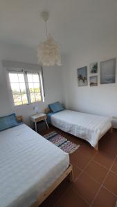 two beds in a room with two windows at Sun And Moon in Ayamonte
