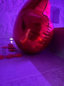 a large red ball in a room with purple lighting at Twins Luxury Suite - Barletta in Barletta