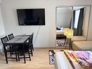 a living room with a dining room table and a tv at Rautatien ullakkohuoneisto in Karkkila
