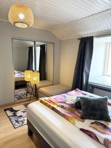 a bedroom with a bed and a mirror at Rautatien ullakkohuoneisto in Karkkila
