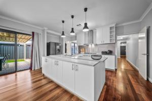 a kitchen with white cabinets and a hard wood floor at Nest in The Vines in The Vines