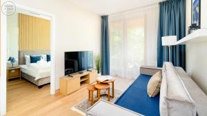 a living room with a couch and a television at Apartamenty Good Time- Mariental Residence - Centrum in Szklarska Poręba +80 photos