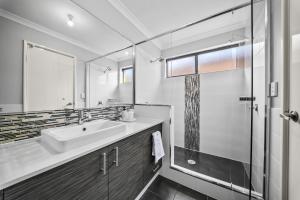 a bathroom with a sink and a glass shower at Nest in The Vines in The Vines +34 photos