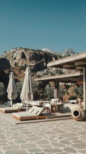 a pavilion with umbrellas and tables and chairs at Klay Hotel Faralya Adults Only in Faralya