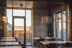 a restaurant with tables and chairs and a large window at Black Beach Suites in Vík