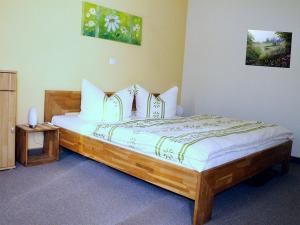 a bedroom with a large wooden bed in a room at Hotel & Gasthaus Forelle in Thale