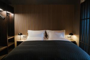 a bedroom with a large bed with two white pillows at Black Beach Suites in Vík