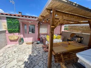 a patio with a wooden table and a pergola at Maison Donarosa Charmant in Vieille-Brioude