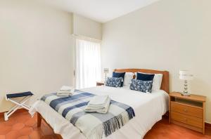 a bedroom with a bed with a blue and white blanket at Apartamento Village Elvas in Vilamoura