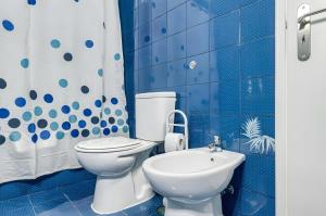 a blue bathroom with a toilet and a sink at Apartamento Village Elvas in Vilamoura +12 photos