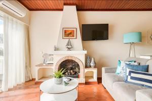 a living room with a couch and a fireplace at Apartamento Village Elvas in Vilamoura