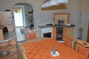 a kitchen with a table and a stove top oven at Gästehaus Manuela in Lind